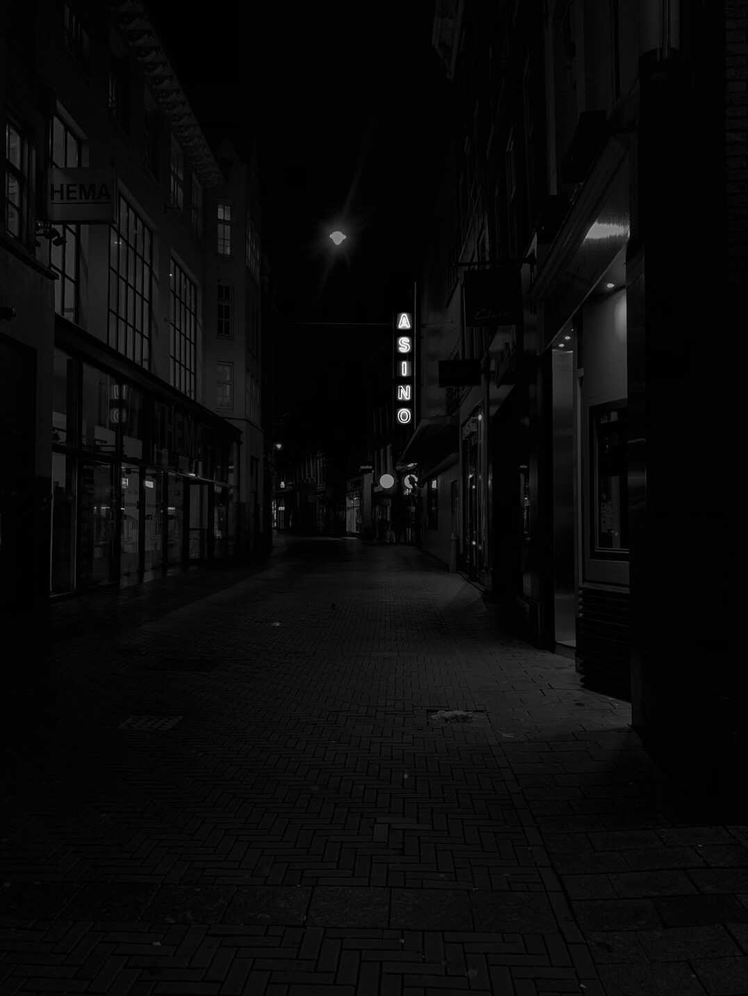 Noir style empty alley with dramatic shadows and a single light