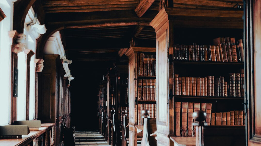 Interior of an old wood-paneled library with tall bookshelves